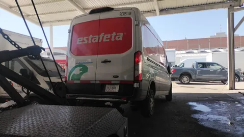 Camioneta de reparto de Estafeta cargada sobre la plataforma de Grúas MG